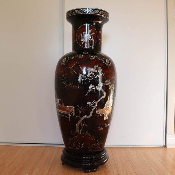 The back of a dark brown traditional Vietnamese lacquer vase depicting a serene landscape with scholars and artists.